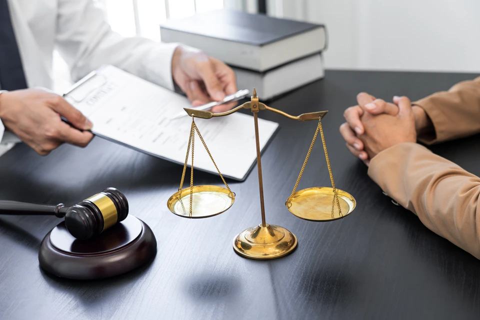 Scène de consultation juridique dans un bureau avec avocat présentant des documents à un client